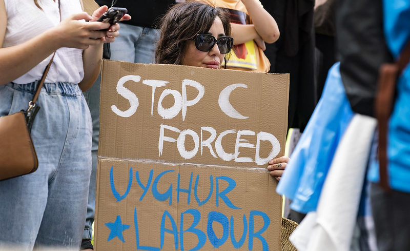 « Stop au travail forcé des Ouighours », peut-on lire sur la pancarte de cette manifestante lors d’une mobilisation de soutien envers les Ouighours organisée à Melbourne en Australie en mars 2022. ©Matt Hrkac, Flickr CC