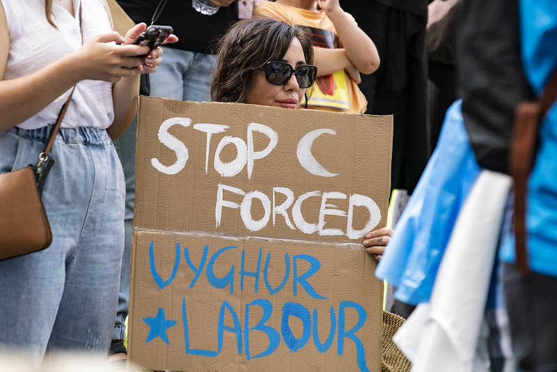 « Stop au travail forcé des Ouighours », peut-on lire sur la pancarte de cette manifestante lors d’une mobilisation de soutien envers les Ouighours organisée à Melbourne en Australie en mars 2022. ©Matt Hrkac, Flickr CC