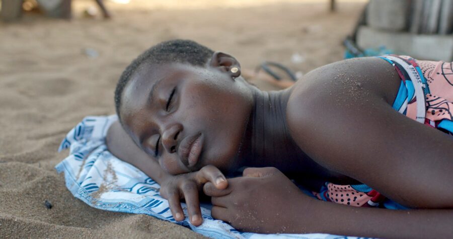 Chérissant le sable de son île, Aya profite un temps de l’insouciance de l’enfance. Crédit : DR.
