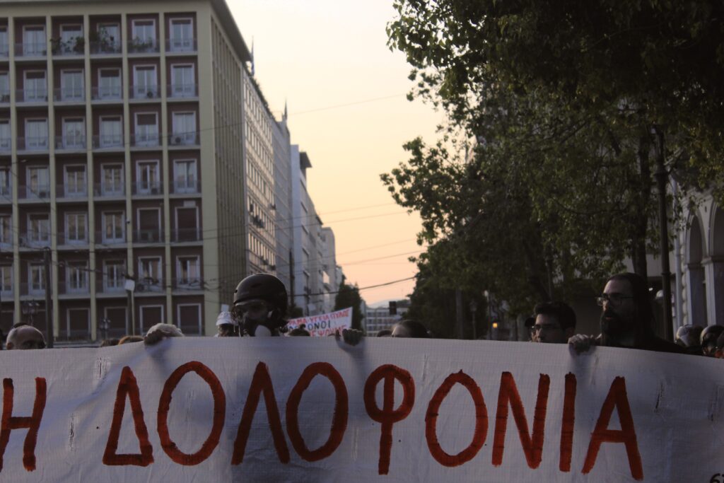 « Assassins » titre une banderole lors suite à l'appel national à manifester pour les victimes du naufrage, le 13 juillet 2023. (Crédits : Elza Goffaux pour GuitiNews)